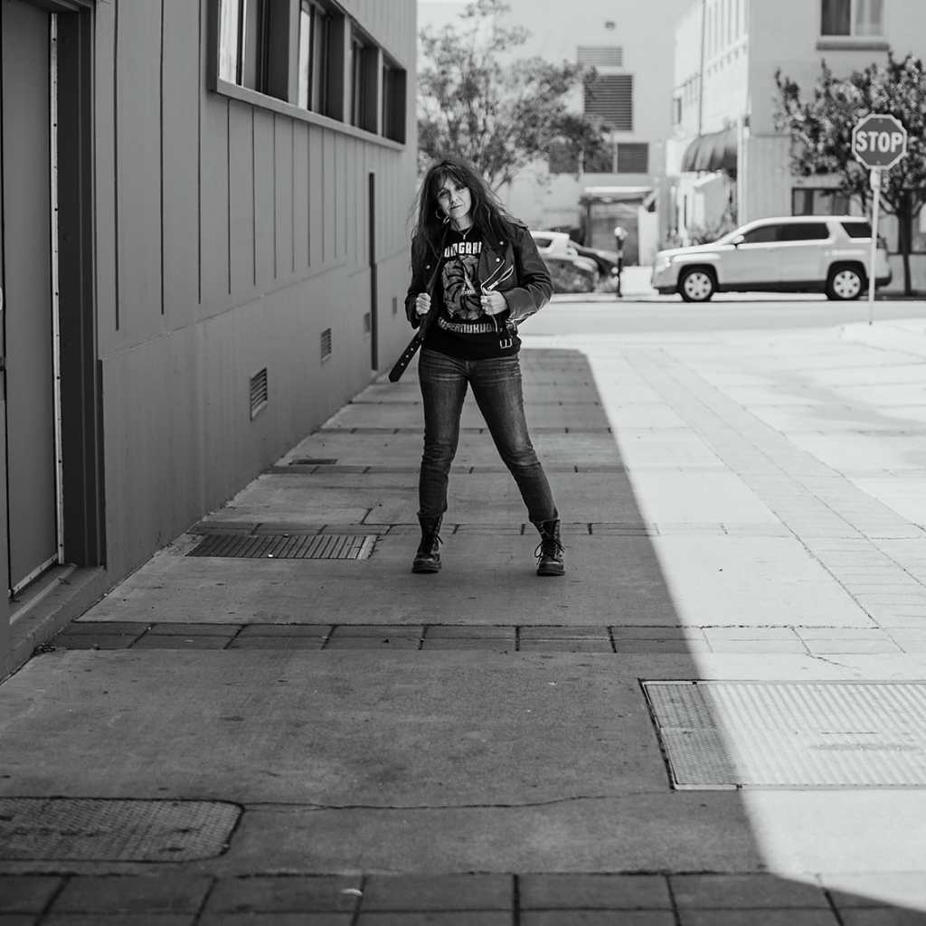 Woman standing in alley wearing a Soundgarden t-shirt and leather jacket | Rock & Roll Jane | Officially licensed band tees and accessories