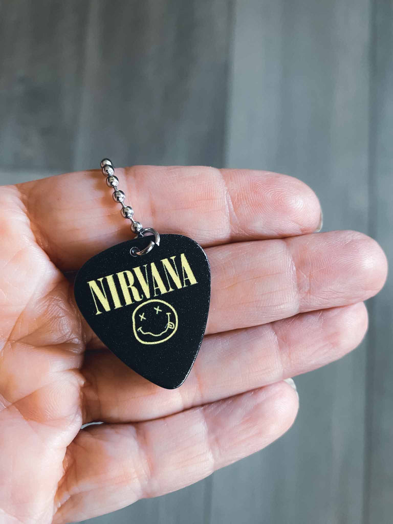 Nirvana Happy Face Guitar Pick Necklace | Black with yellow logo and happy face | Band merch | Rock & Roll Jane | Officially licensed band tees and band merch