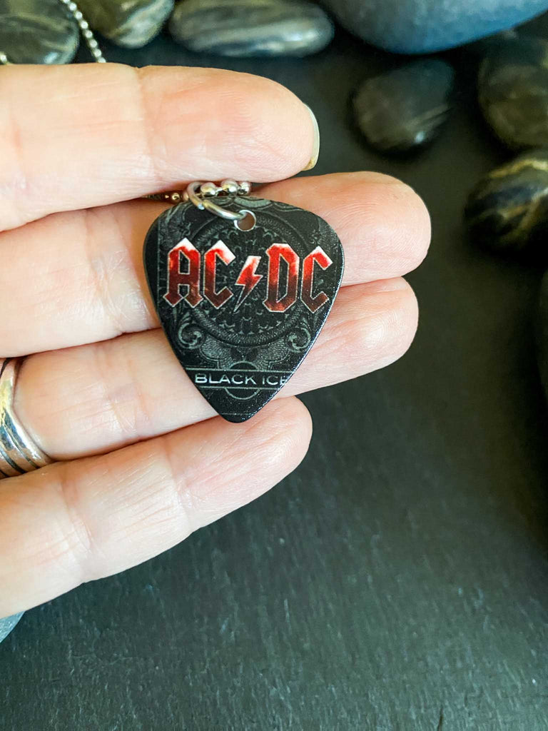AC/DC guitar pick necklace featuring Black Ice artwork on an 18" stainless steel ball chain. Band merch at Rock & Roll Jane.