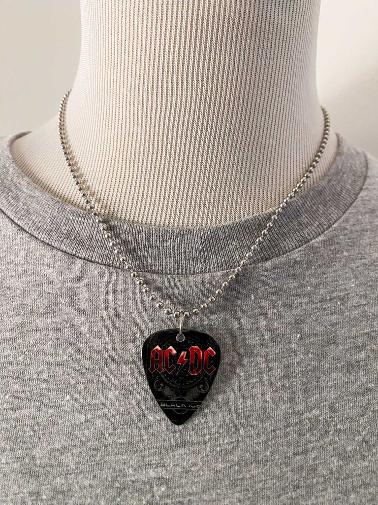 AC/DC guitar pick necklace featuring Black Ice artwork on an 18" stainless steel ball chain. Band merch at Rock & Roll Jane. Displayed on a mannequin.