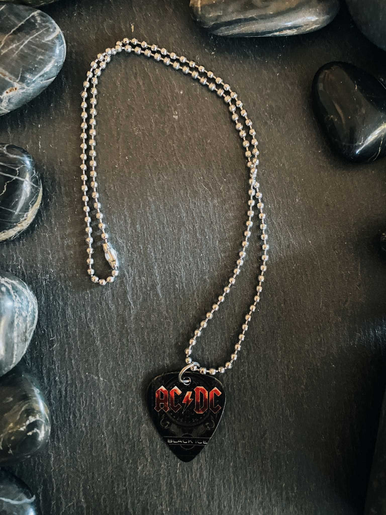 AC/DC guitar pick necklace featuring Black Ice artwork on an 18" stainless steel ball chain. Band merch at Rock & Roll Jane.