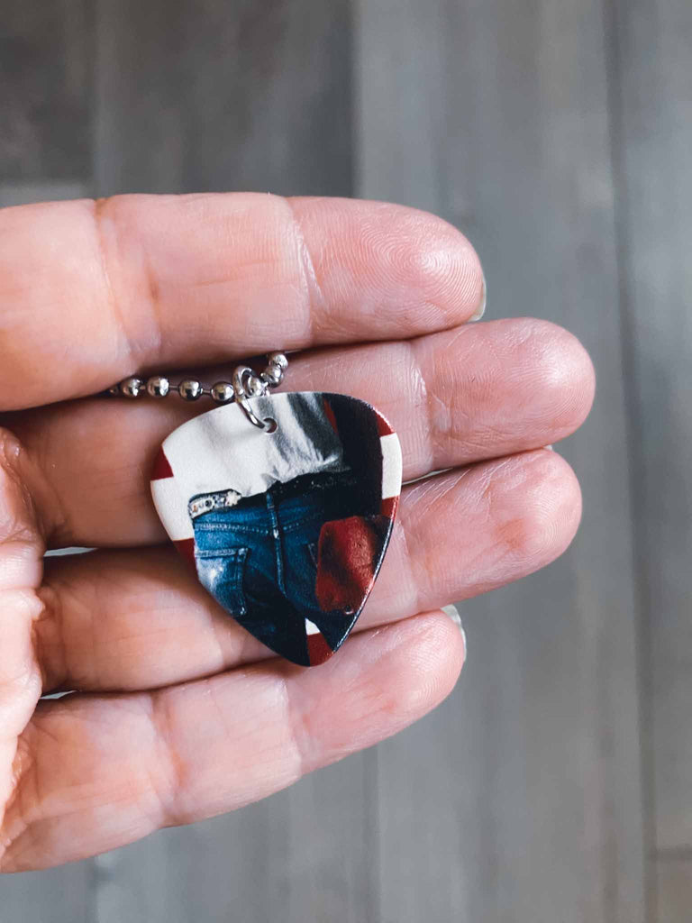 Bruce Springsteen Guitar Pick Necklace featuring artwork from Springsteen's album "Born in the USA" | hangs on an 18" silver ball chain and comes with an extra cord | Available at Rock & Roll Jane | We carry officially licensed band tees and accessories