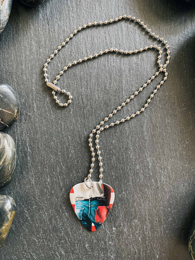 Bruce Springsteen Guitar Pick Necklace featuring artwork from Springsteen's album "Born in the USA" | hangs on an 18" silver ball chain and comes with an extra cord | Available at Rock & Roll Jane | We carry officially licensed band tees and accessories