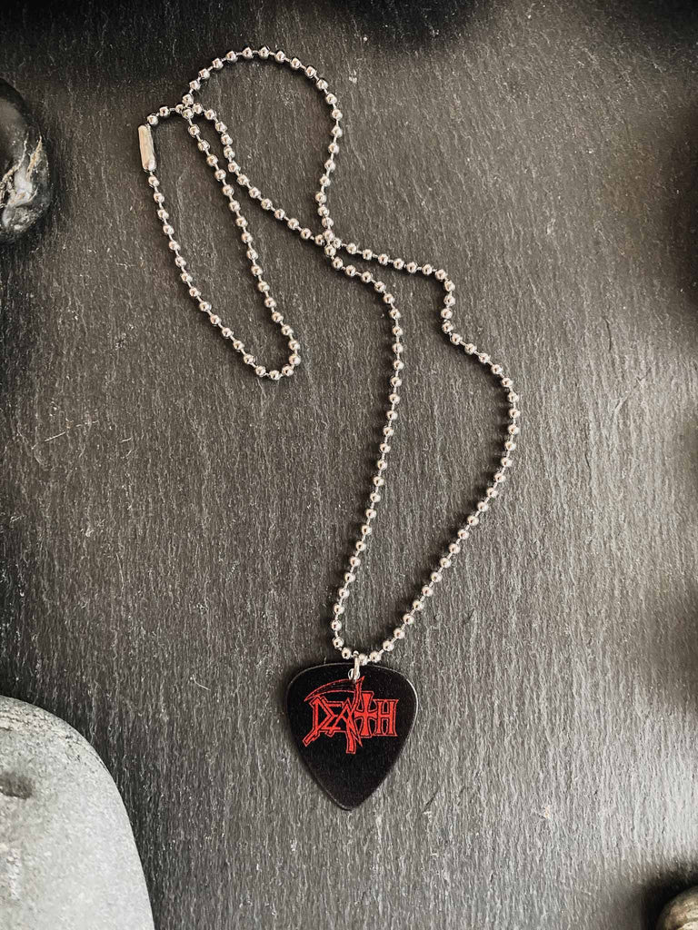Death Guitar Pick necklace featuring the band's logo in red on both side | 18" silver ball chain plus an extra cord for versatility | Buy officially licensed band tees and band merch at Rock & Roll Jane