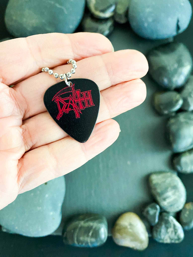 Death Guitar Pick necklace featuring the band's logo in red on both side | 18" silver ball chain plus an extra cord for versatility | Buy officially licensed band tees and band merch at Rock & Roll Jane