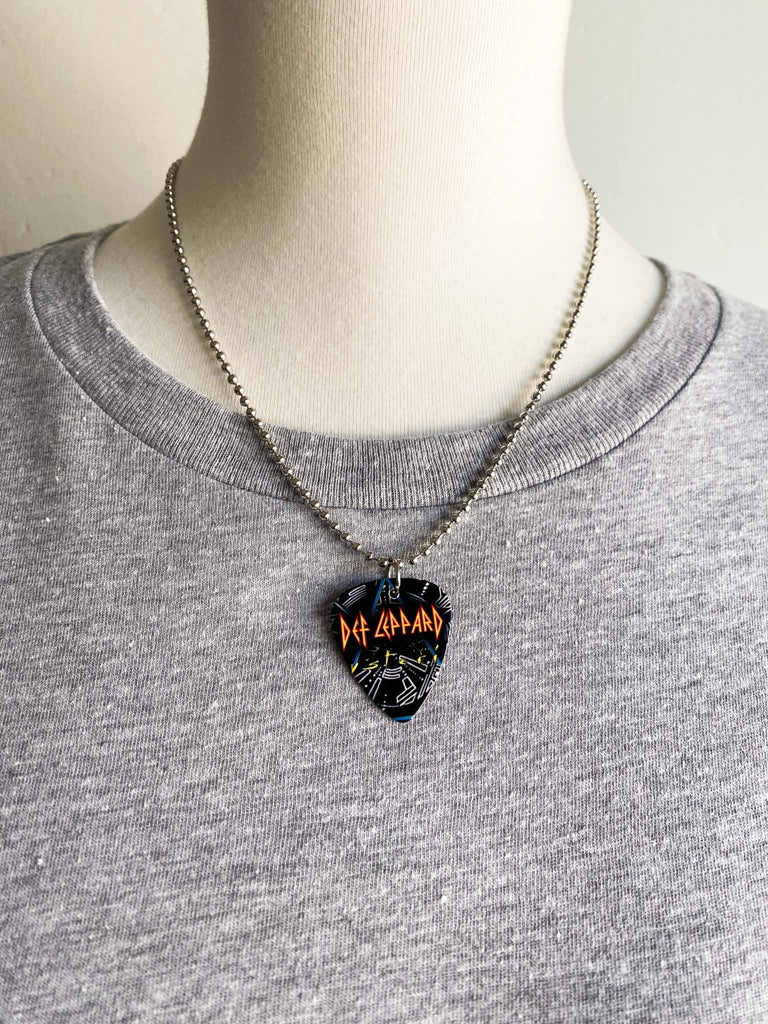 Def Leppard Guitar Pick Necklace featuring graphic on both sides on an 18" stainless steel ball chain | Fast shipping and free stickers with every order | Shop officially licensed band tees and more at Rock & Roll Jane