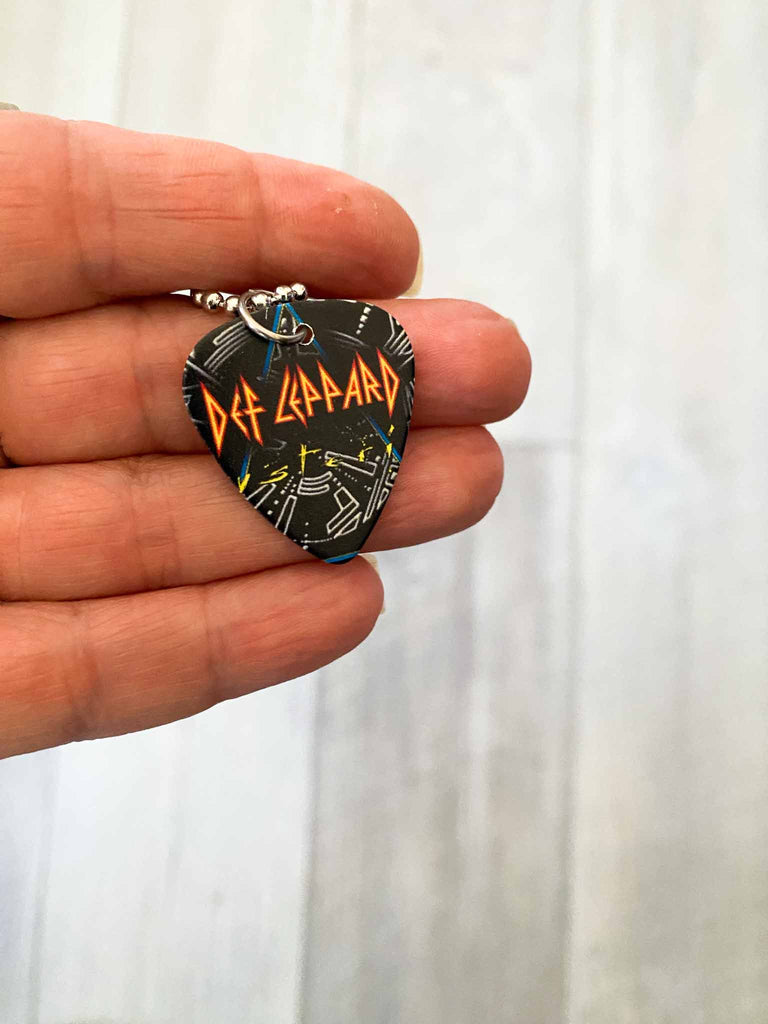 Def Leppard Guitar Pick Necklace featuring graphic on both sides on an 18" stainless steel ball chain | Fast shipping and free stickers with every order | Shop officially licensed band tees and more at Rock & Roll Jane