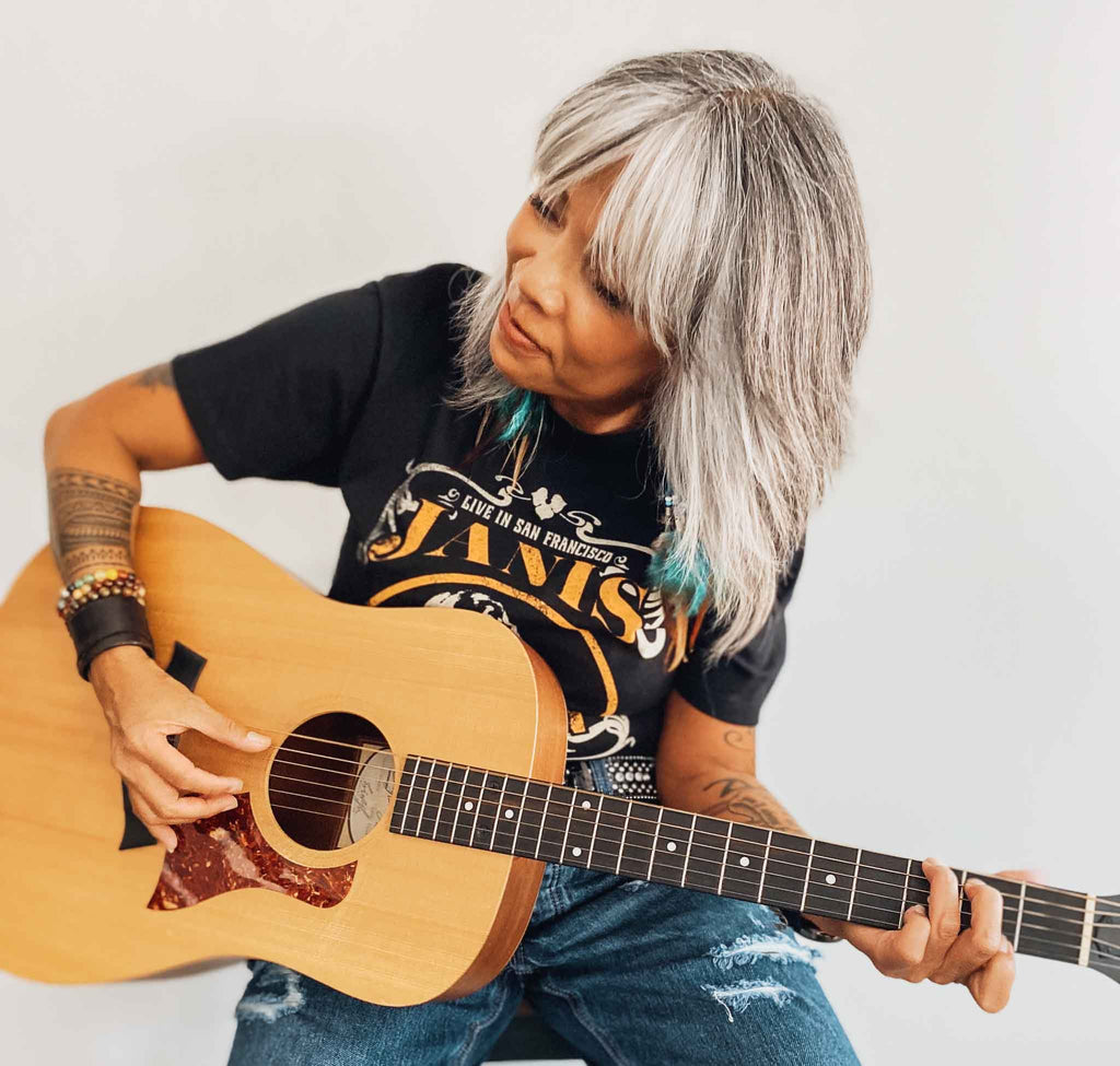 Woman playing guitar and wearing officially licensed Janis Joplin band tee | Rock & Roll Jane
