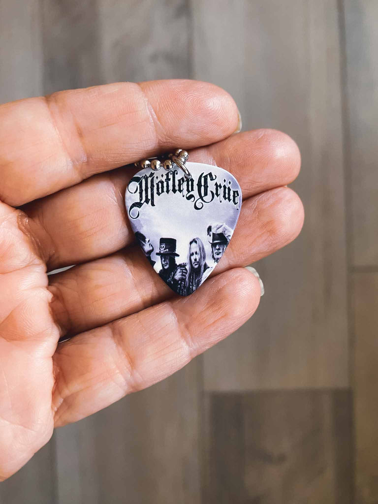 Motley Crue guitar pick necklace | featuring the band's logo and photo | hangs on an 18" silver ball chain and comes with an extra cord | Rock & Roll Jane | We sell officially licensed band tees and accessories
