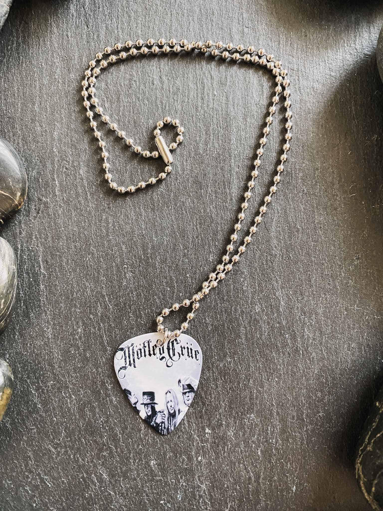 Motley Crue guitar pick necklace | featuring the band's logo and photo | hangs on an 18" silver ball chain and comes with an extra cord | Rock & Roll Jane | We sell officially licensed band tees and accessories