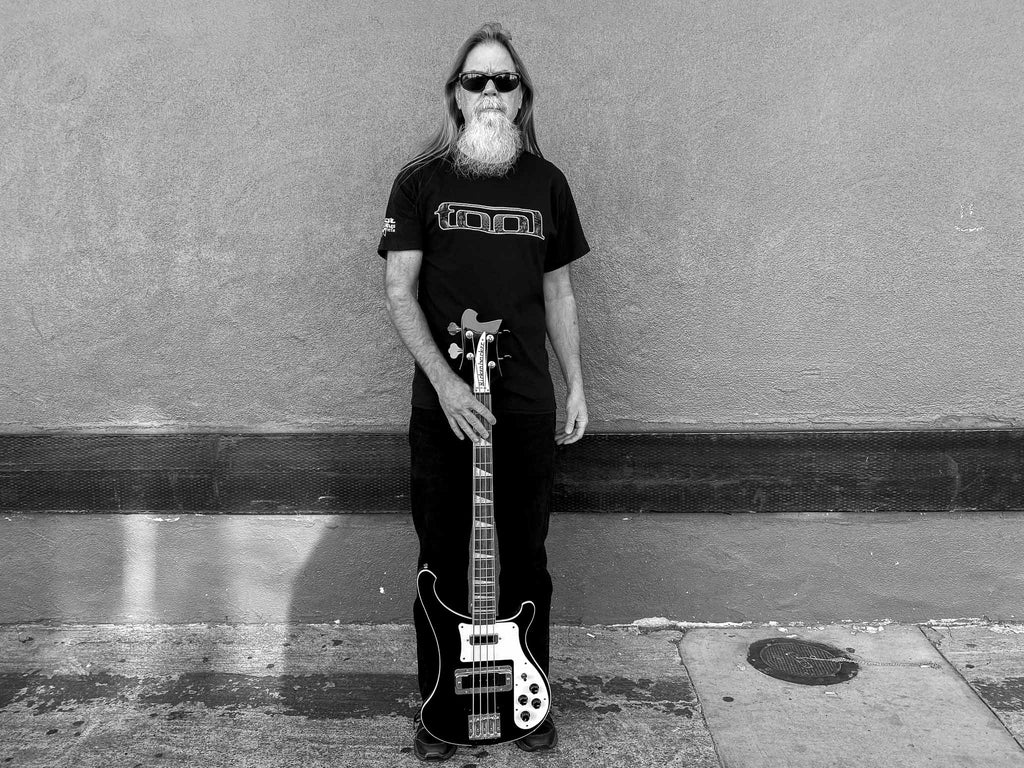 Bass player holding his Rickenbacker bass wearing an officially licensed Tool t-shirt available at Rock & Roll Jane