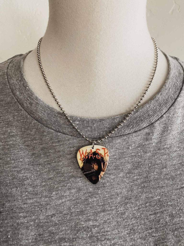 W.A.S.P guitar pick necklace | artwork from the band's 7" single "I Don't Need No Doctor" | 18" silver ball chain with extra cord | Available at Rock & Roll Jane | Officially licensed band tees and accessories